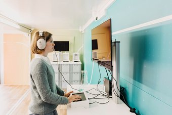 Eine Besucherin an einer Station des mobilen Forschungs-Labs Eine Besucherin an einer Station des mobilen Forschungs-Labs