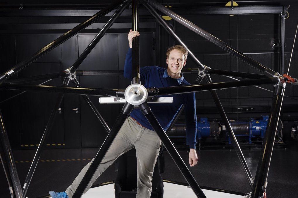 Person steht in dem CableRobot-Simulator