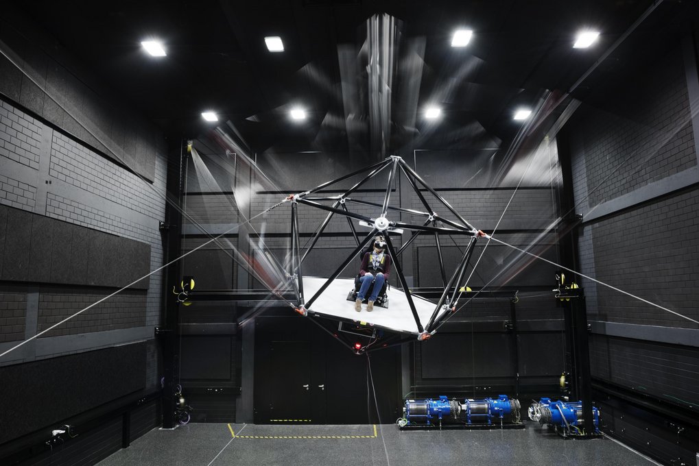 Person mit VR-Brille sitzt in CableRobot-Simulator