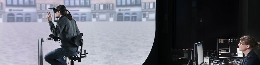 PanoLab Person with VR headset seated, facing a large screen displaying a virtual cityscape.