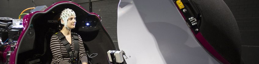 Biosensors Person with EEG cap seated in the CyberMotion Simulator.