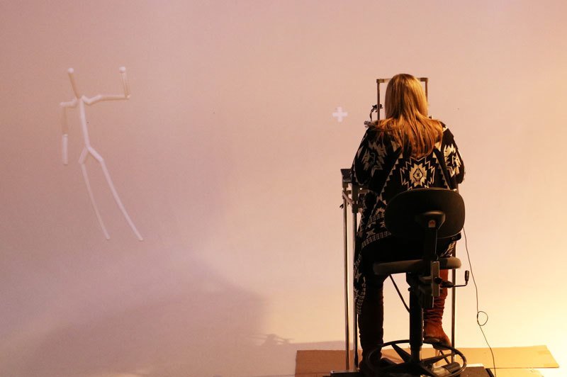 Avatar (left) on a curved panoramic screen with 230 degree field of view: the avatar is located on the subject's edge of the visual field (right) and mimicks human movements.